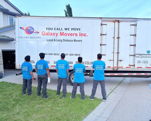 Galaxy Movers team standing beside a moving truck