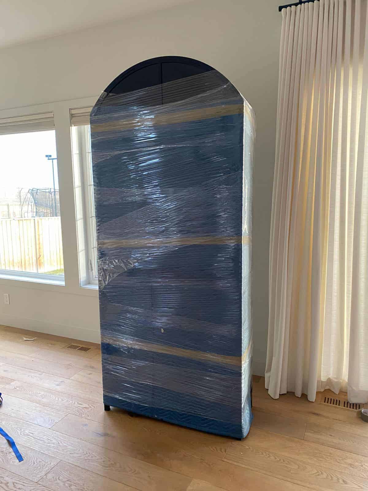 Moving wardrobe wrapped in plastic for protection during a move in Calgary.