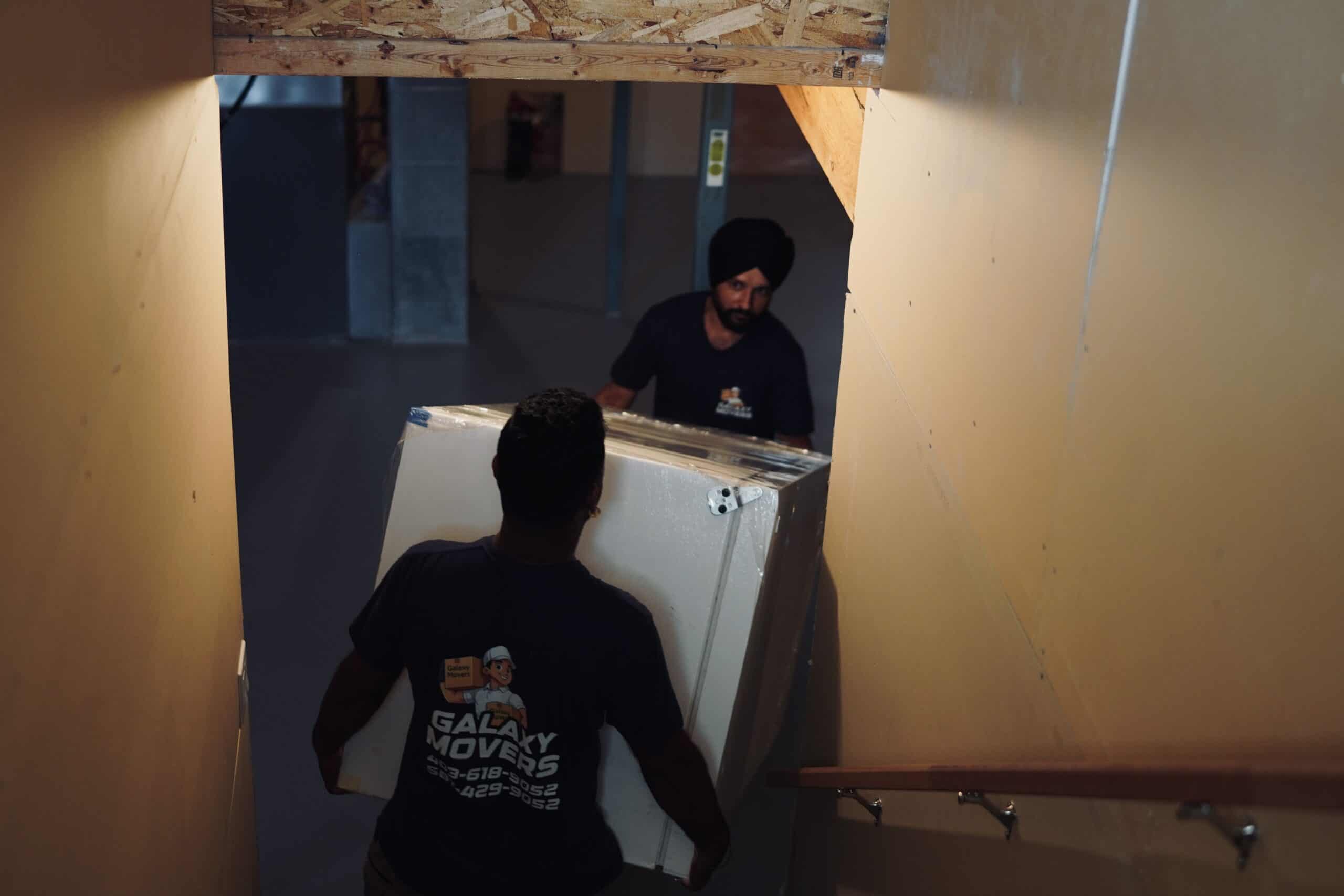 Movers carrying a refrigerator down a staircase in Beaumont