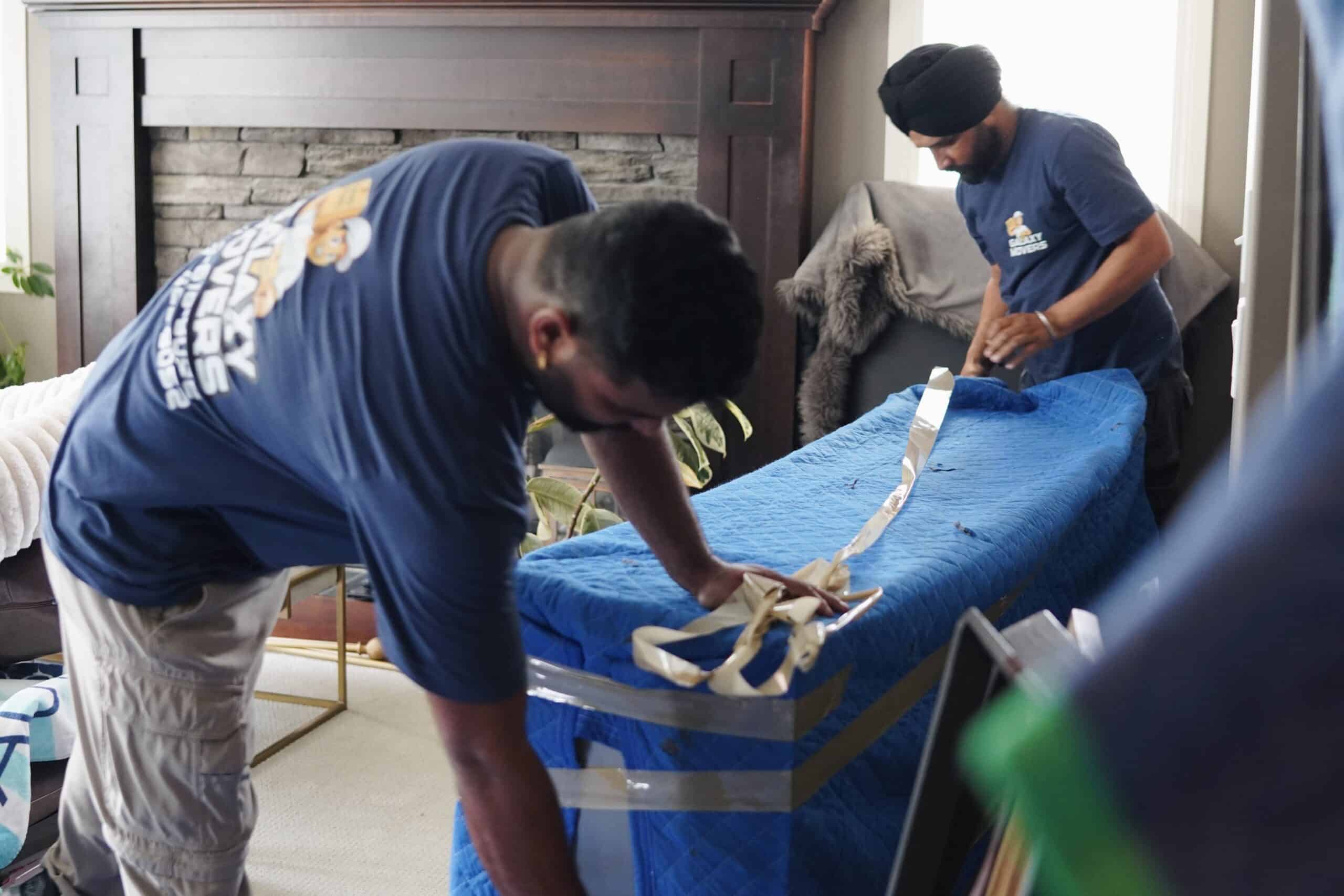 Movers carefully handling a large item in Camrose