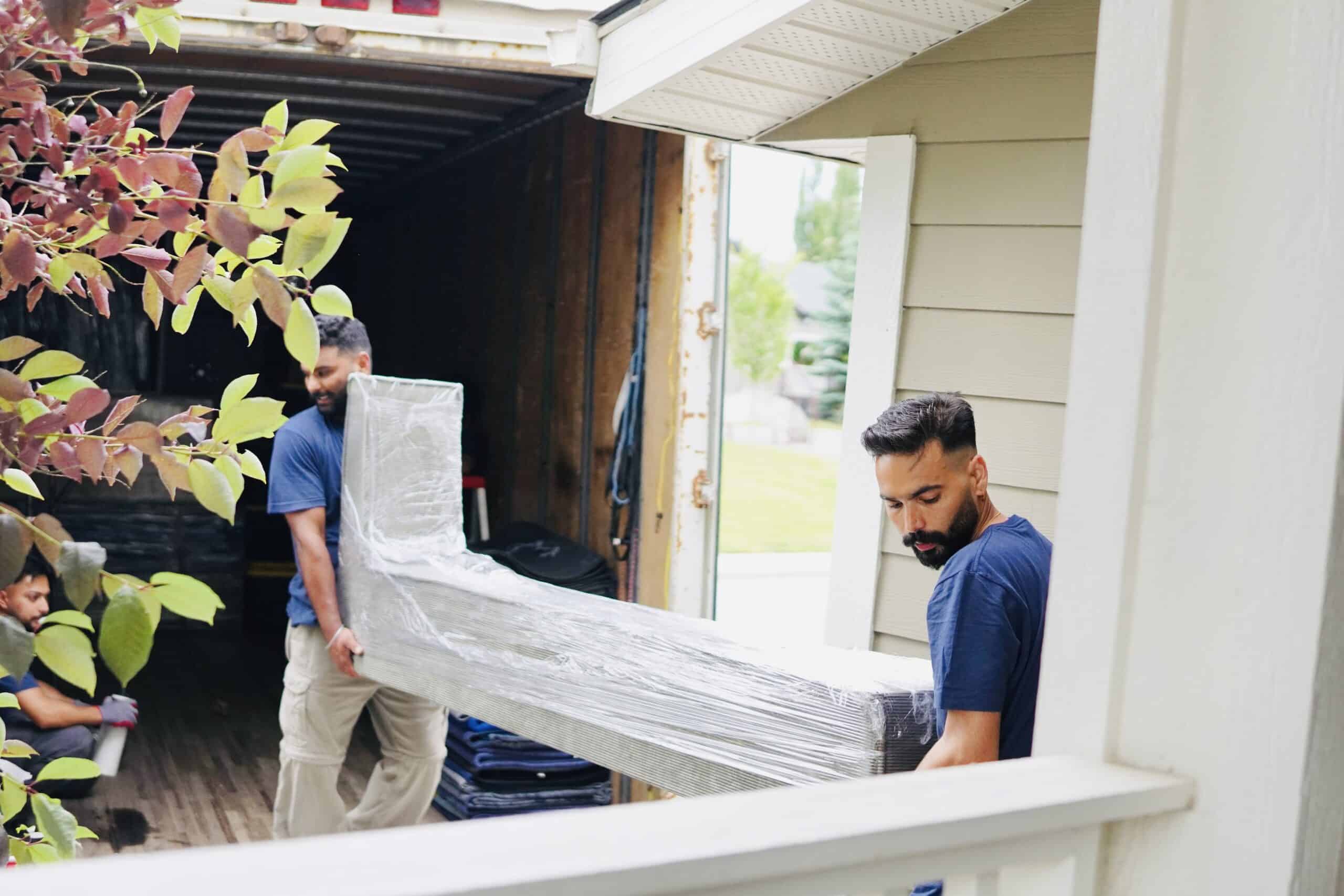 Movers carrying furniture in Calgary for professional relocation service.