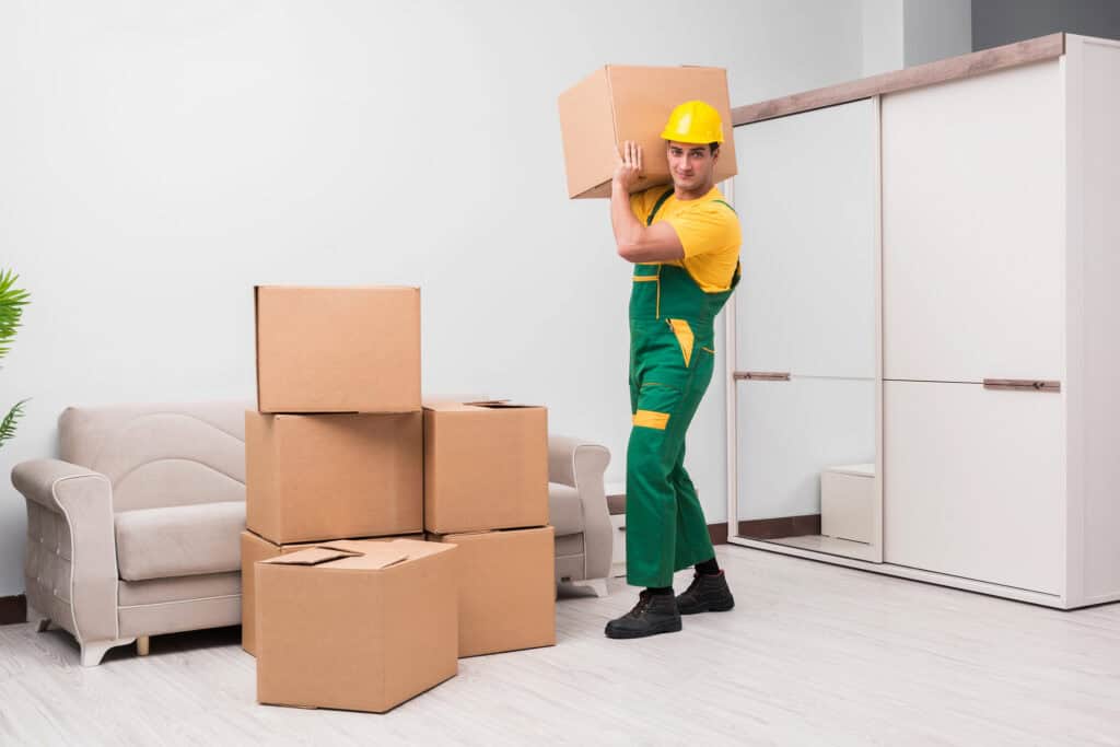 Mover carrying a box in a modern living room for local moving services.