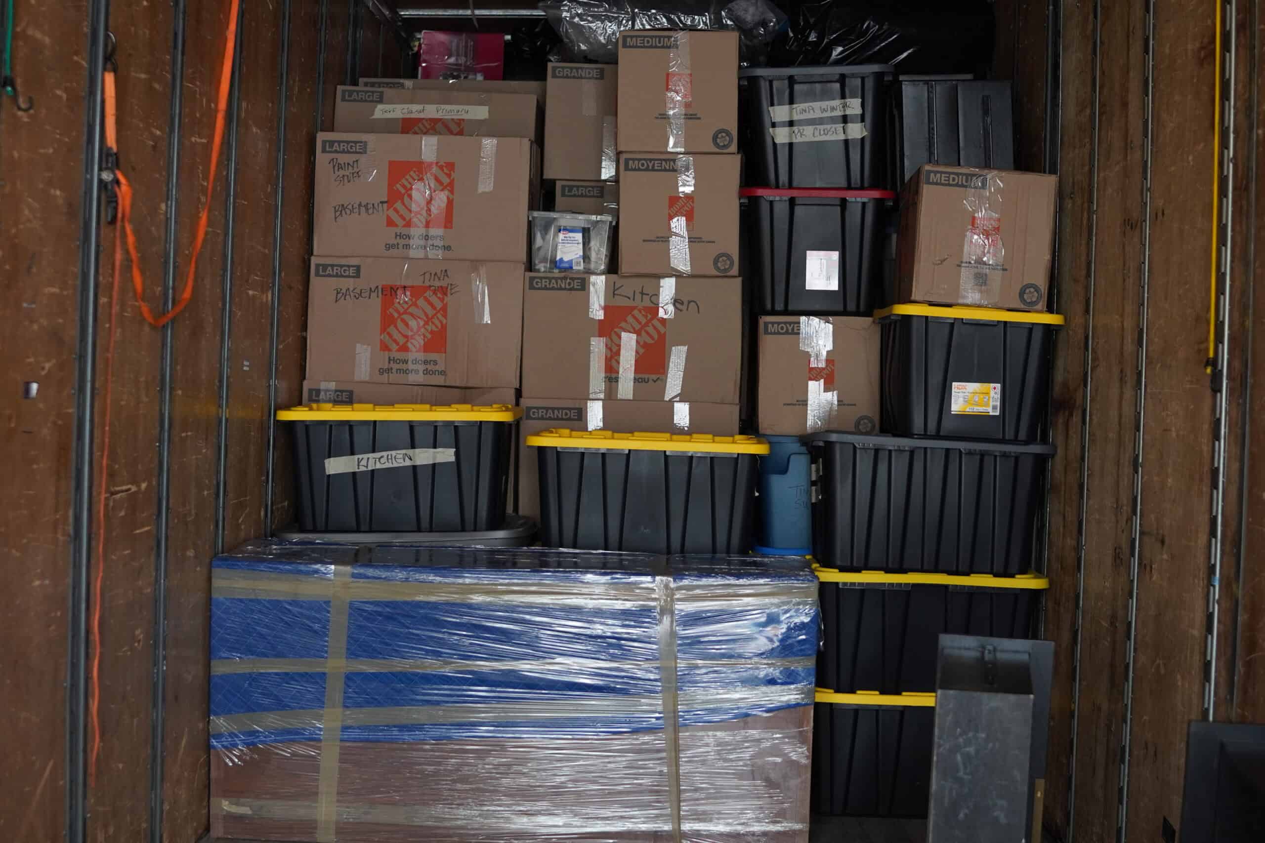 Stacked moving boxes and containers inside a moving truck in Calgary.