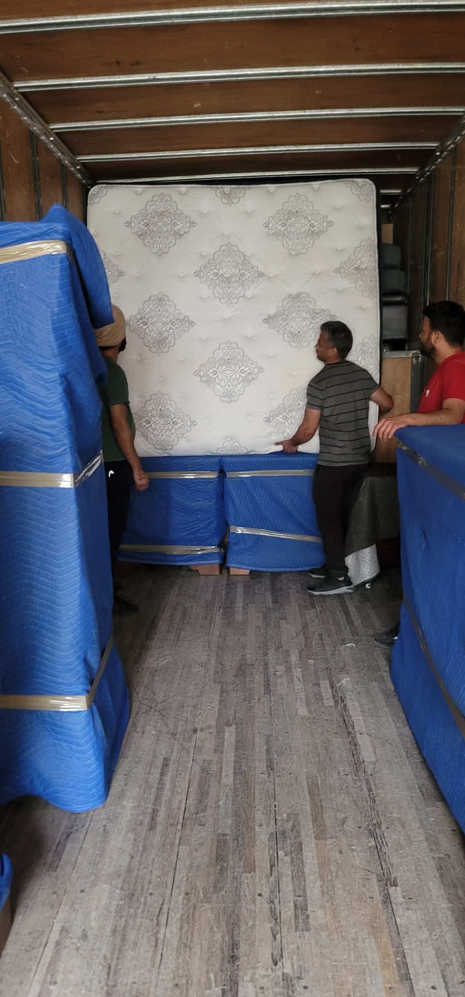 Professional movers handling a mattress during a Calgary move