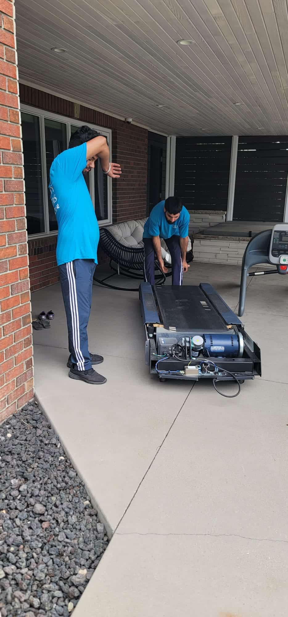Movers preparing equipment for a move on a covered porch