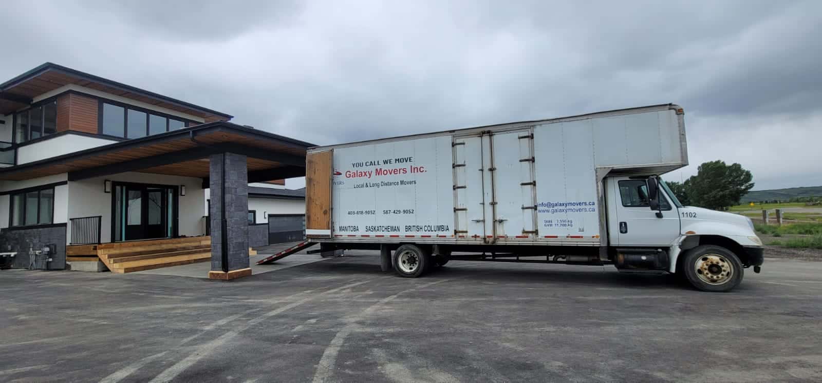 Moving truck parked outside modern house in Calgary for Galaxy Movers