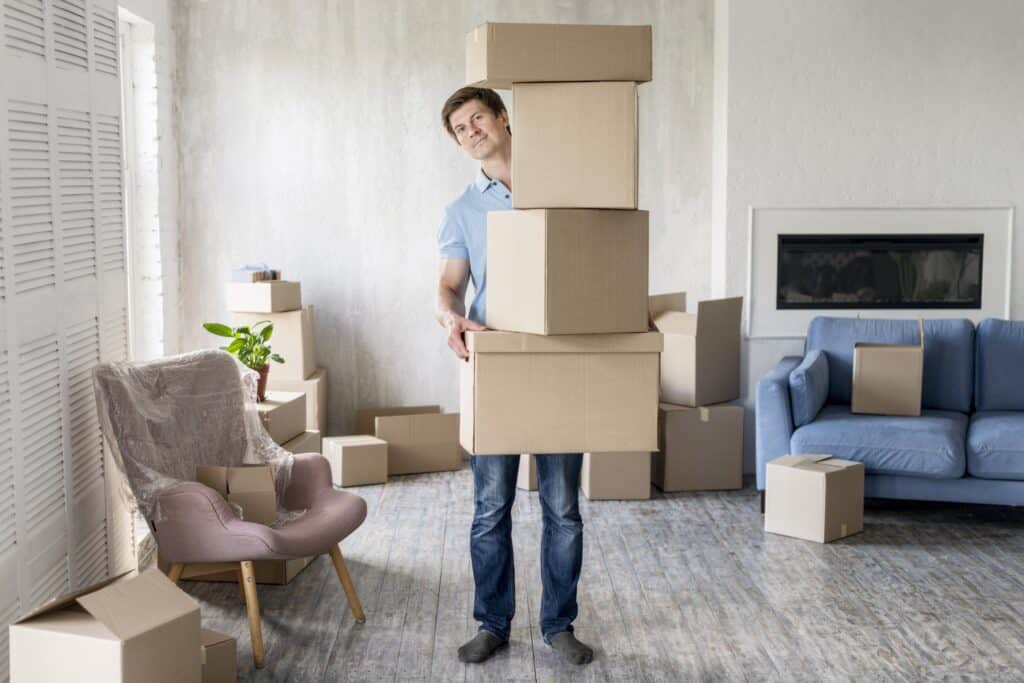 Man carrying moving boxes during a house relocation