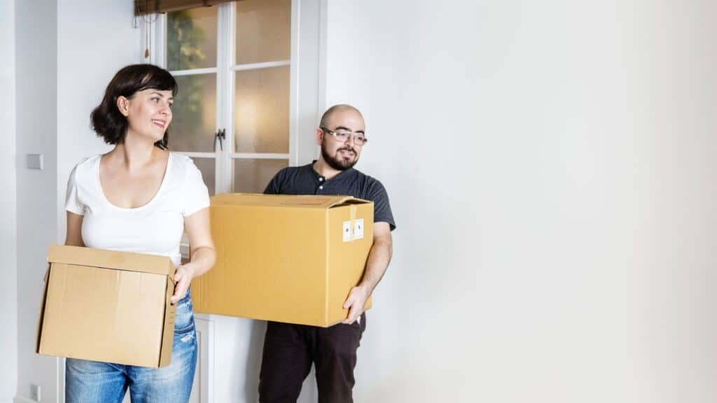 Two movers carrying boxes in a home during a move in Lethbridge AB.