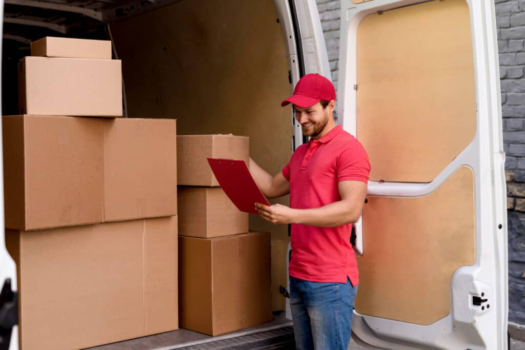 Mover checking inventory with boxes in a moving van in Westlock.
