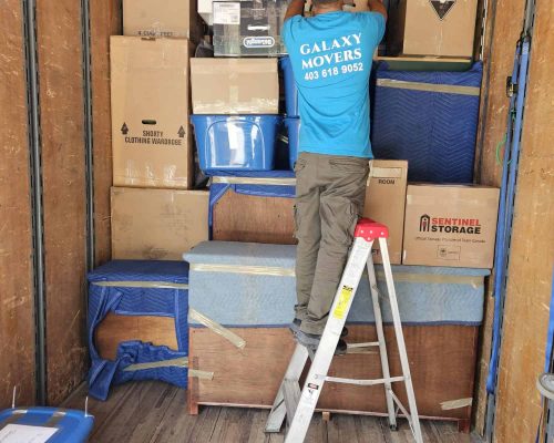 Moving company professional packing boxes in a truck for Calgary relocations.